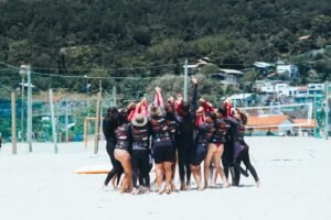 Grupo de pessoas juntas comemorando o in[icio de uma aula coletiva de surf.