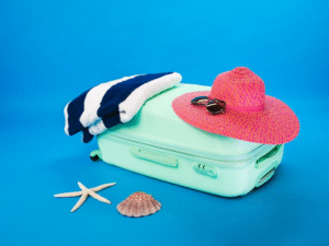 conjunto de mala, toalha, chapéu e óculos, organizados de maneira harmônica, com uma estrela do mar e concha, fazendo analogia a uma viagem praiana.