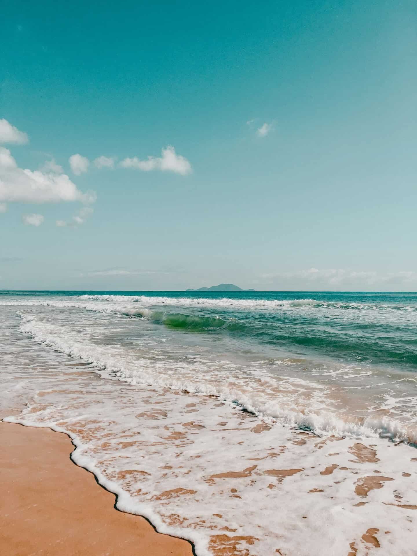 Vista da praia da Barra da Lagoa em Florianópolis, com ondas chegando à areia