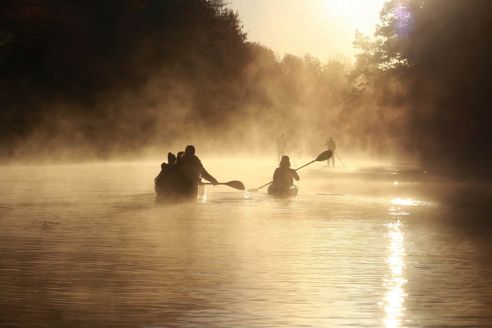 Grupo praticando canoa havaiana ao amanhecer