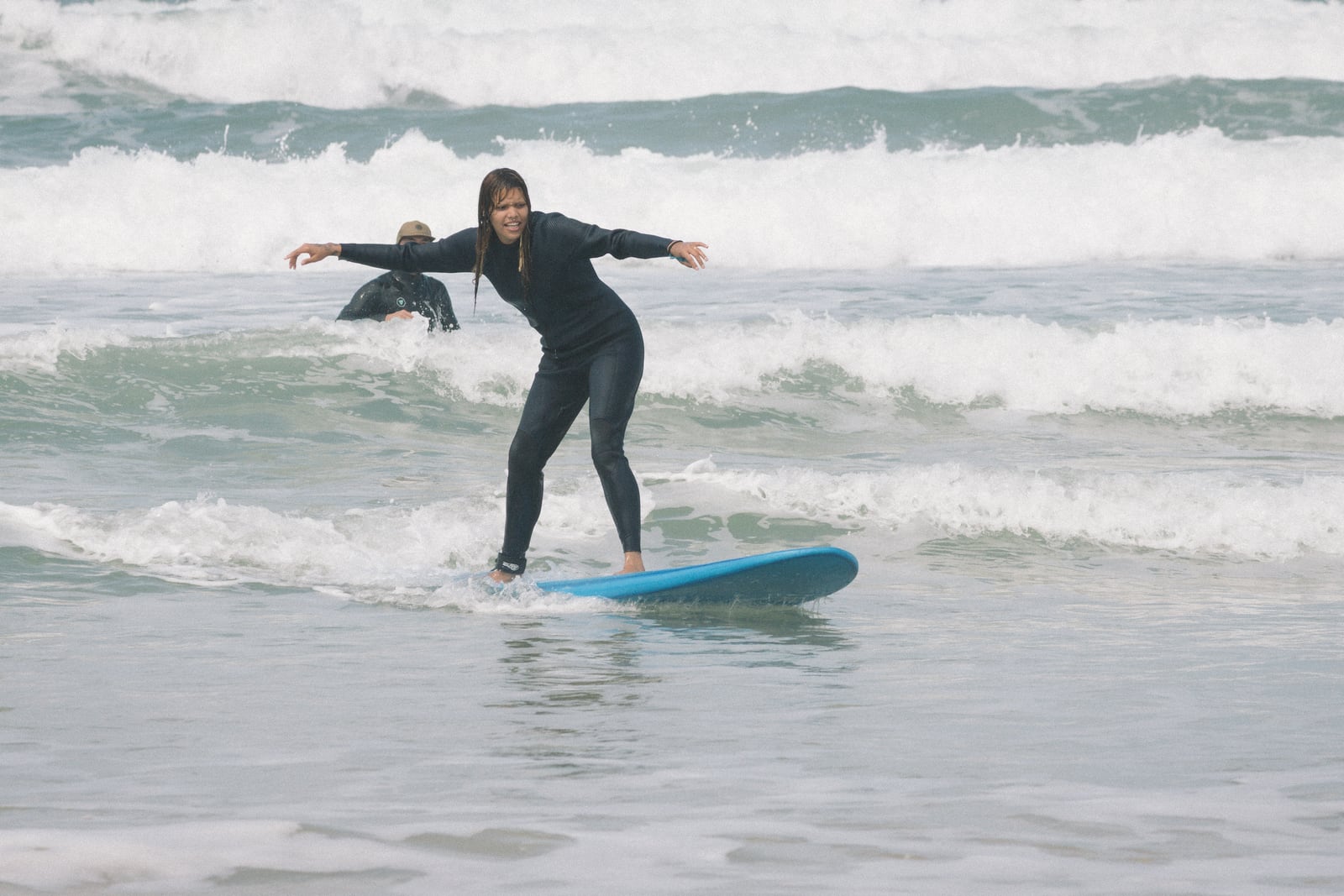 Alumna de pie en la tabla en su primera clase de surf, playa de Campeche