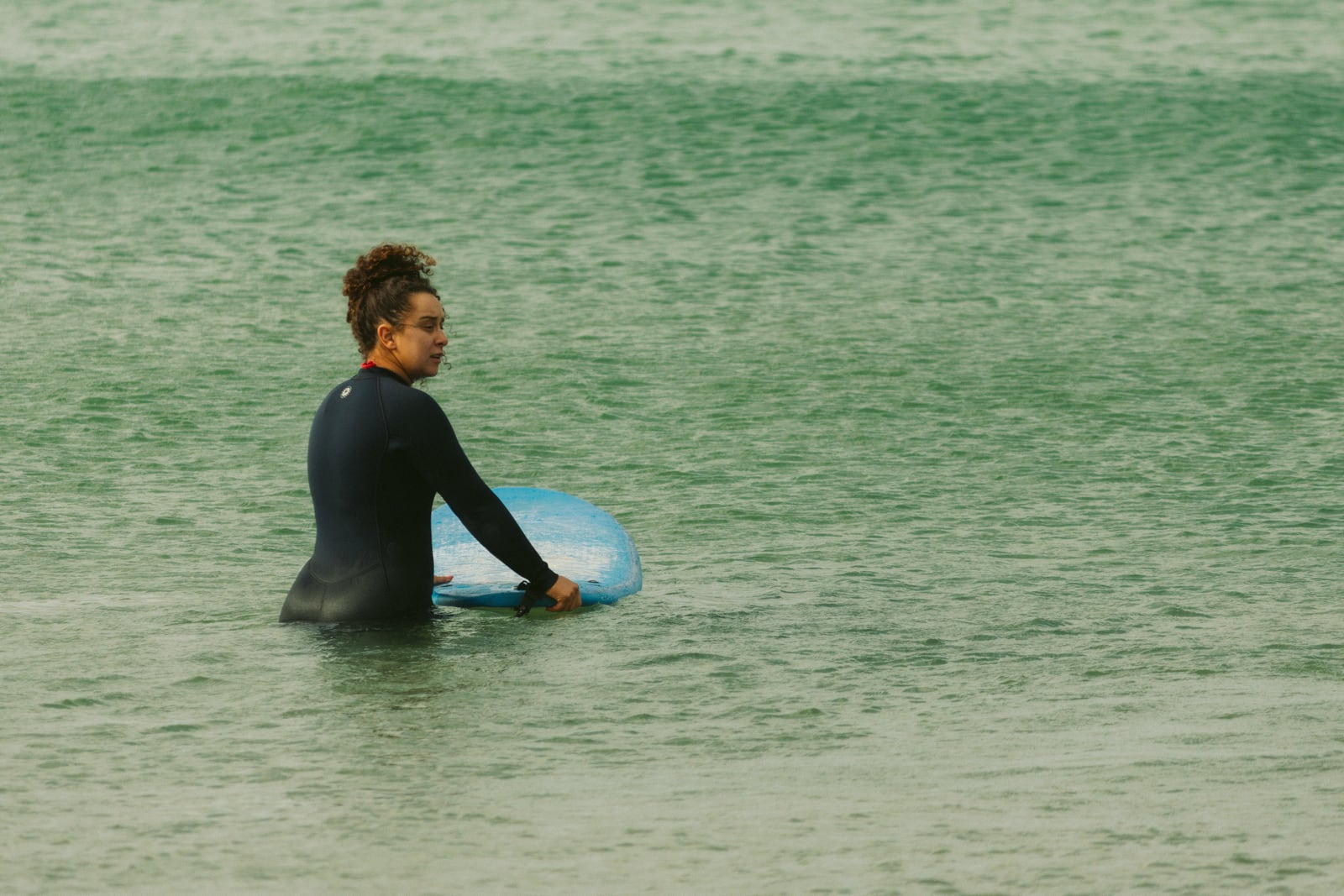 Surfista con la tabla en el mar de Barra da Lagoa, Florianópolis